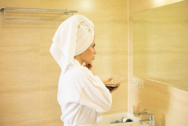 Banyoda makyaj yapan bornoz sarışın kadın portresi