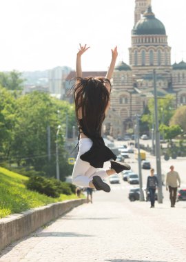 Kentsel arka planda atlama eğlenceli ince esmer kadın Portresi