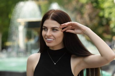 Park arka planda poz veren ince esmer kadın portresi