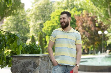 Parkta poz çizgili t-shirt genç sakallı adam