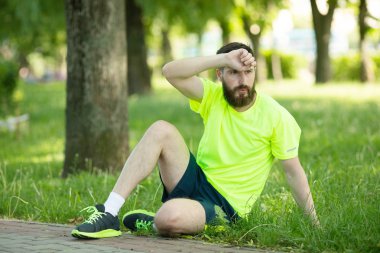 Genç yorgun sakallı adam parkta eğitim den sonra istirahat