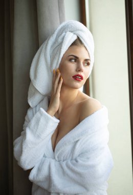 Otel odasında poz bornoz parlak makyaj ile sarışın kadın Portresi