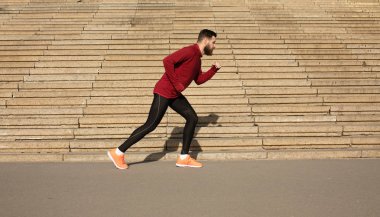 Merdiven arka planda çalışan spor giyim genç sakallı adam