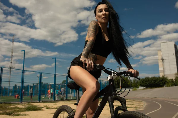 Bisikletli Genç Bir Kadın Yolda Dikiliyor Bir Yerlere Bakıyor — Stok fotoğraf