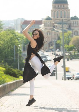 Kentsel arka planda atlama eğlenceli ince esmer kadın Portresi