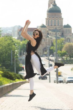 Kentsel arka planda atlama eğlenceli ince esmer kadın Portresi