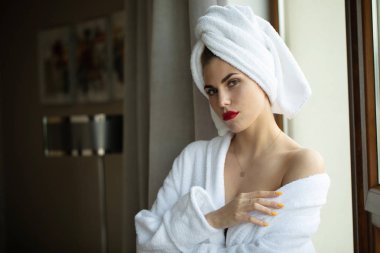 Otel odasında poz bornoz parlak makyaj ile sarışın kadın Portresi