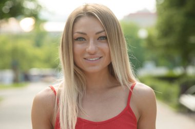 Bulanık park arka plan üzerinde poz genç sarışın fit kadın Portresi