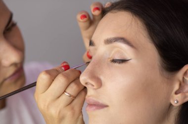 Makyaj sanatçı göz farları uygular. Makyaj ustasının eli, model gözleri boyama.