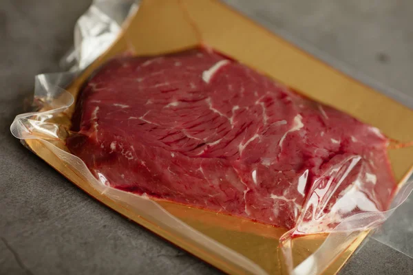 Beaf steak vacuum sealed ready for sous vide cooking on black background, top view.