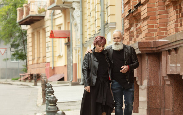 Happy senior couple in love during retirement . Joyful elderly lifestyle with man whispering and smiling with her wife.