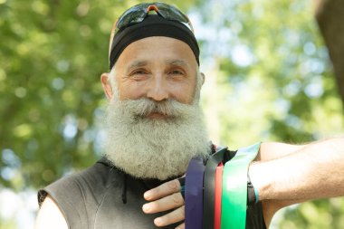 Sakallı yaşlı sunucu lastik bant. Spor, spor, sağlıklı yaşam tarzı konsepti.