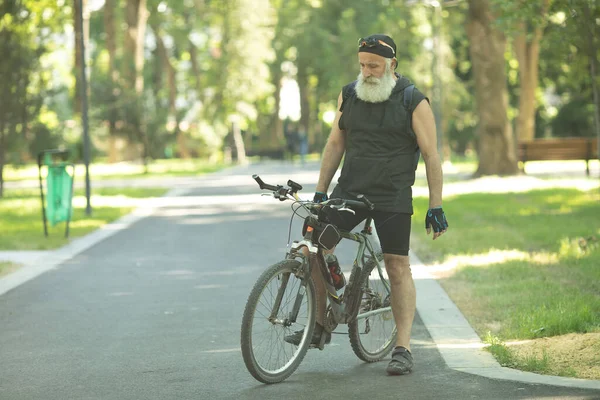 Γενειοφόρος Ώριμος Αθλητικός Άνδρας Στέκεται Ποδήλατο Στο Πολύχρωμο Καλοκαιρινό Πάρκο — Φωτογραφία Αρχείου