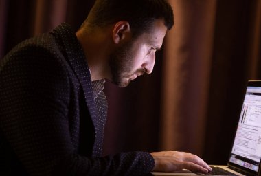 Zarif iş adamı otel odasında oturuyor ve gece geç saatlere kadar çalışıyor..