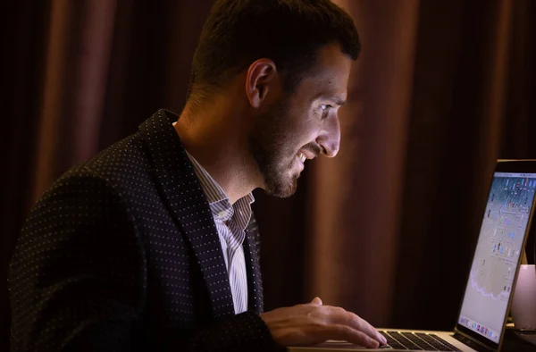 stock image Elegant businessman sitting in hotel room and working late at night.