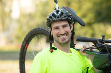 Yaz parkında bisikletli genç ve atletik bir adam..