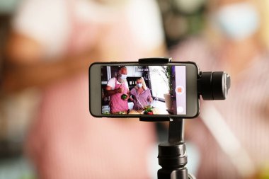 Güzel sevgili blogcuları mutfaktan yemek pişiriyor. COVID-19. Seçici odak.