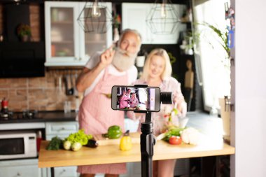 Güzel sevgili blogcuları mutfaktan yemek pişiriyor. COVID-19. Seçici odak.