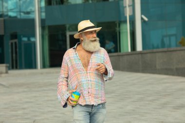 Şehir merkezlerinde kahve molası veren yaşlı, sakallı hippi bir adamın portresi..