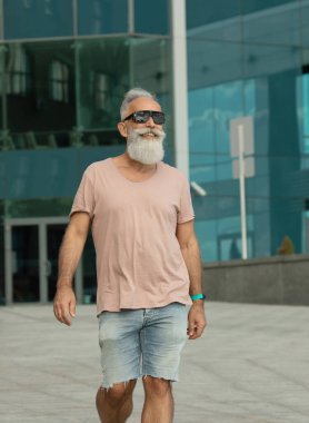 Şık bir hippi. Şehirde yürüyen olgun bir adam.