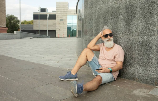 Hipster Starší Muž Pomocí Smartphone Opírající Budovy Městě — Stock fotografie