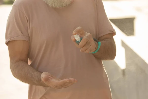 Man Using Sanitizer Outdoors — Stock Photo, Image