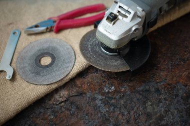 Paslı arka planda ingiliz anahtarı ve pensesi olan öğütücü aracı