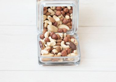 Beyaz ahşap arka planda cam kavanozda yer fıstıkları