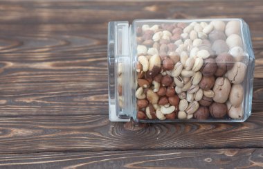 Koyu ahşap arka planda cam kavanozda yer fıstıkları