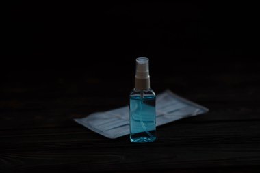 El dezenfektanı. El dezenfekte etmek için antibakteriyel sprey. Tüm virüs ve bakterilerden korunma. Siyah arka planda pompalı bir dezenfektan şişesi..