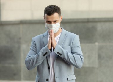 İş adamı yüz maskesi takıyor ve virüsün yayılmasını önlemek için namaste ile selamlaşıyor. Covid 19.