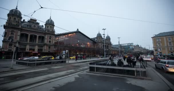 Uma vista do tráfego da cidade em frente a uma estação ferroviária histórica — Vídeo de Stock