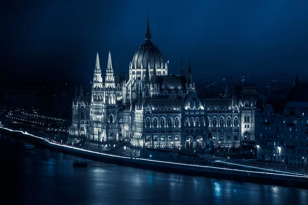 Vista nocturna del famoso edificio del Parlamento húngaro con el río Danubio — Foto de Stock
