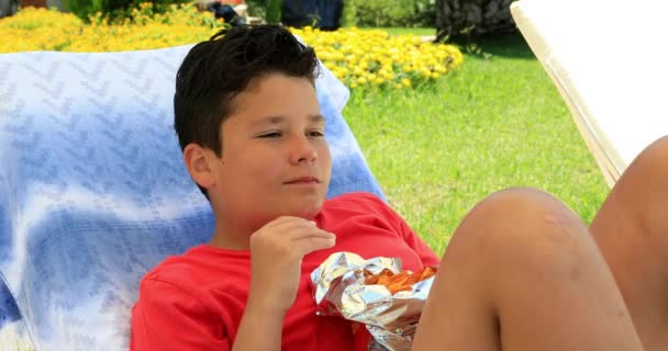 Retrato Lindo Colegial Preadolescente Acostado Una Tumbona Comiendo Papas Fritas — Vídeos de Stock