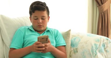 Smartphone manifatura iletisiyle koltuk döşeme veya evde oyun oynarken varoluş çocuk. Teknoloji, Internet iletişim ve insan kavramı