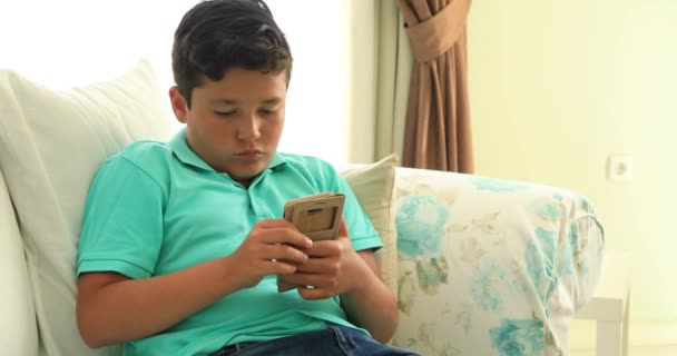 Preteen Pojke Soffa Med Smartphone Sms Meddelande Eller Spelar Spel — Stockvideo