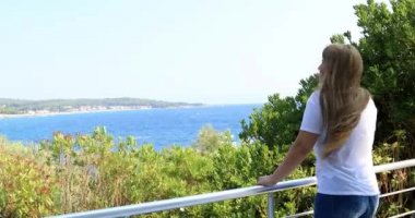 Deniz manzaralı terasta duran genç kadın zevk yaz gün