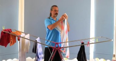 Giysi kurutma makinesi bir raf üzerinde asılı adam