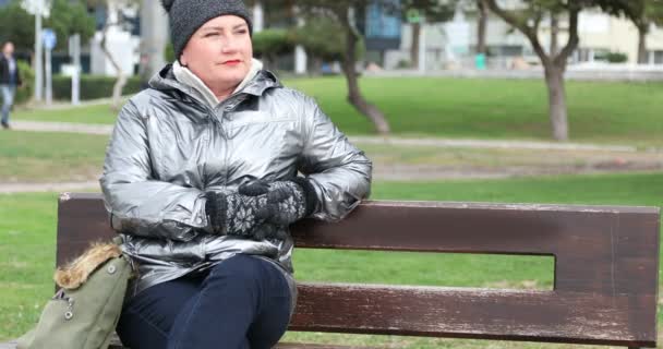 Mujer Sentada Banco Con Abrigo Invierno Mirando Cámara Sonriendo — Vídeos de Stock