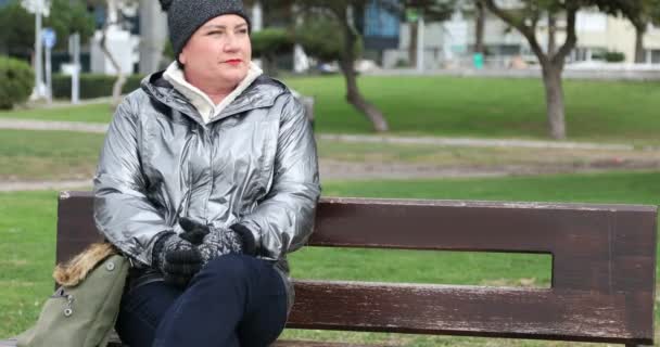 一个女人坐在冬城公园的长椅上 — 图库视频影像