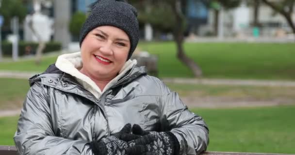 Πορτρέτο Του Μια Ευτυχισμένη Γυναίκα Χειμωνιάτικα Ρούχα Κάθεται Ένα Παγκάκι — Αρχείο Βίντεο