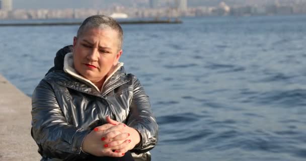 坐在海边的灰发中的悲伤女人 — 图库视频影像