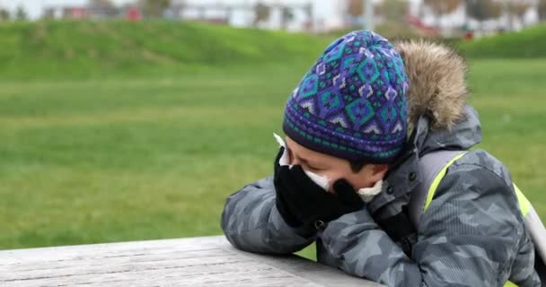 寒い日の屋外の暖かい服を着て中にくしゃみ病気の子供 — ストック動画