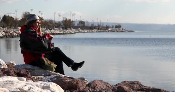 Жінка Середнього Віку Зимовим Одягом Сидить Березі Розслабляється Відкритому Повітрі — стокове відео