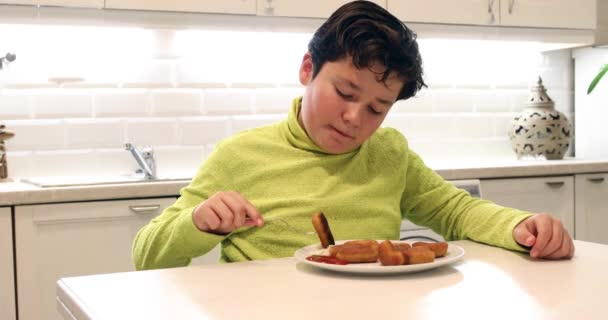 Портрет Мальчика Поедающего Куриные Наггетсы Смотрящего Камеру Кухне — стоковое видео