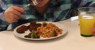 Bir yakışıklı, esmer çocuk köftesi ve pirinç yeme portresi