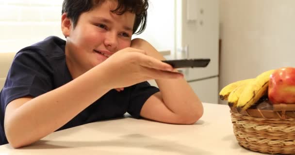 Πορτρέτο Ενός Ευτυχισμένο Προεφηβικό Αγόρι Τηλεχειριστήριο Παρακολουθεί Τηλεόραση Στην Κουζίνα — Αρχείο Βίντεο