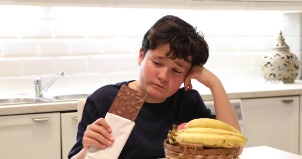 Portret Van Een Kaukasische Preteen Jongen Kiezen Tussen Fruit Chocolade — Stockvideo