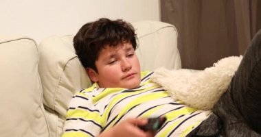 Yorgun genç kanepede yatan ve evde tv izlerken 3