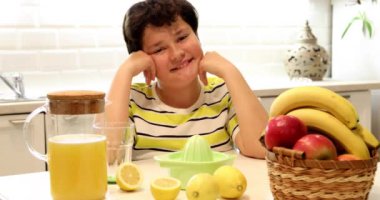Limonata yapan ve kameraya gülümseyen genç bir çocuğun portresi